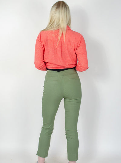 Model is wearing a sage green ankle pull on pant with small slits at the ankles. Pant is worn with a tank top and salmon colored button up.