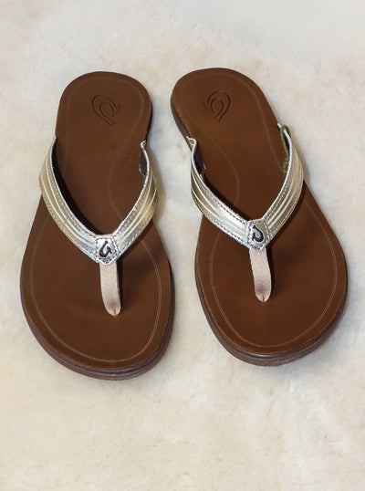 Brown leather beach sandals with metallic gold accent.