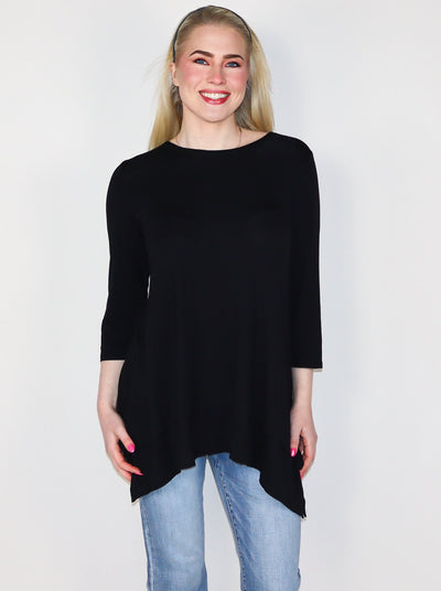 The model is wearing a flowey 3/4th length sleeve black fitted longsleeve. Top is paired with jeans. 