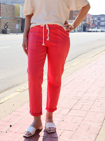 A model wearing a pair of coral faux denim joggers with a white tee.e.