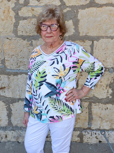 Model is wearing a multi colored tropical printed v-neck tunic top.
