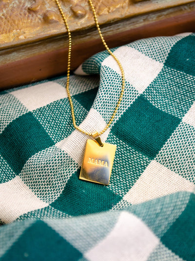 Long Necklace that has a charm with the word "Mama" engraved on it. 