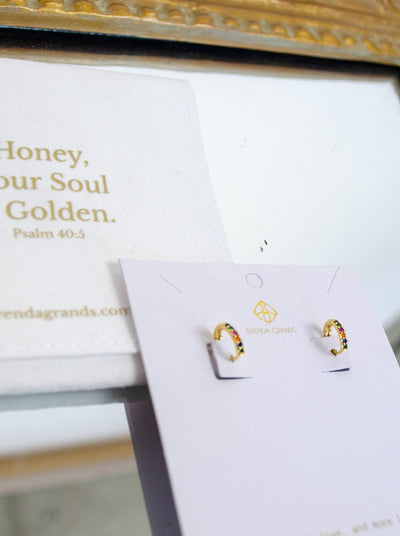 Small dainty gold hoop earrings with rainbow diamond hardware. 