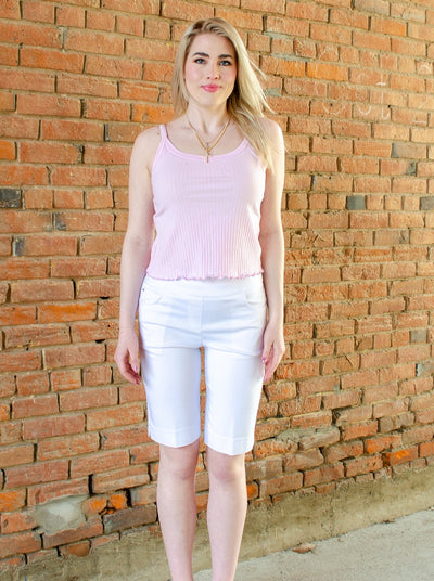 Model is wearing white pull on golf shorts with a tank top.