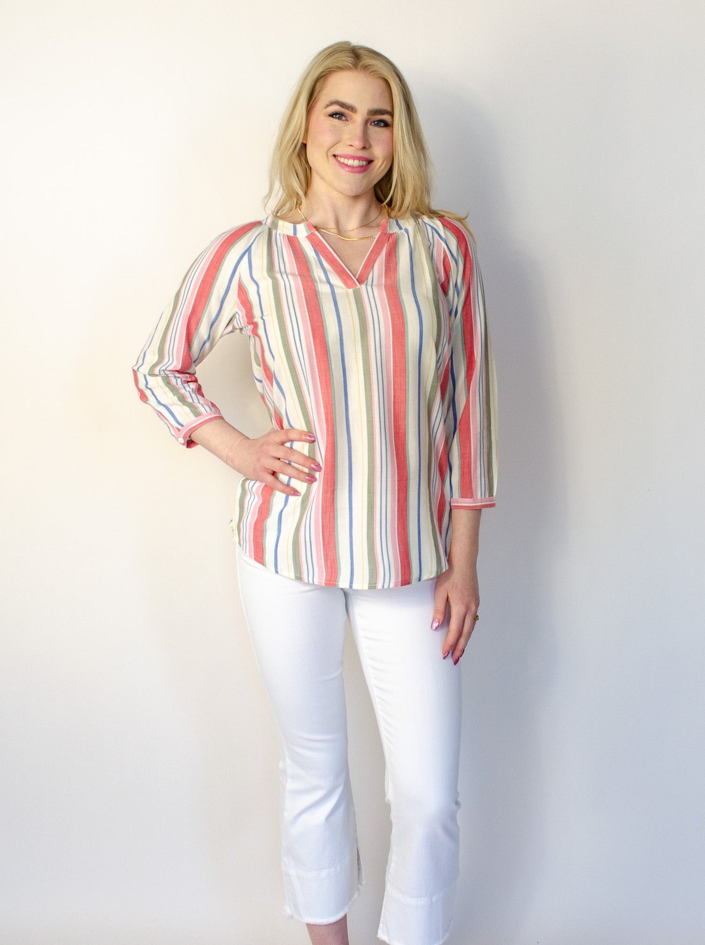 Model is wearing a vertical multi colored striped v-neck long sleeve blouse.