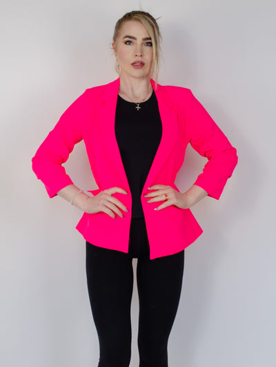 Model is wearing a neon pink fitted blazer.