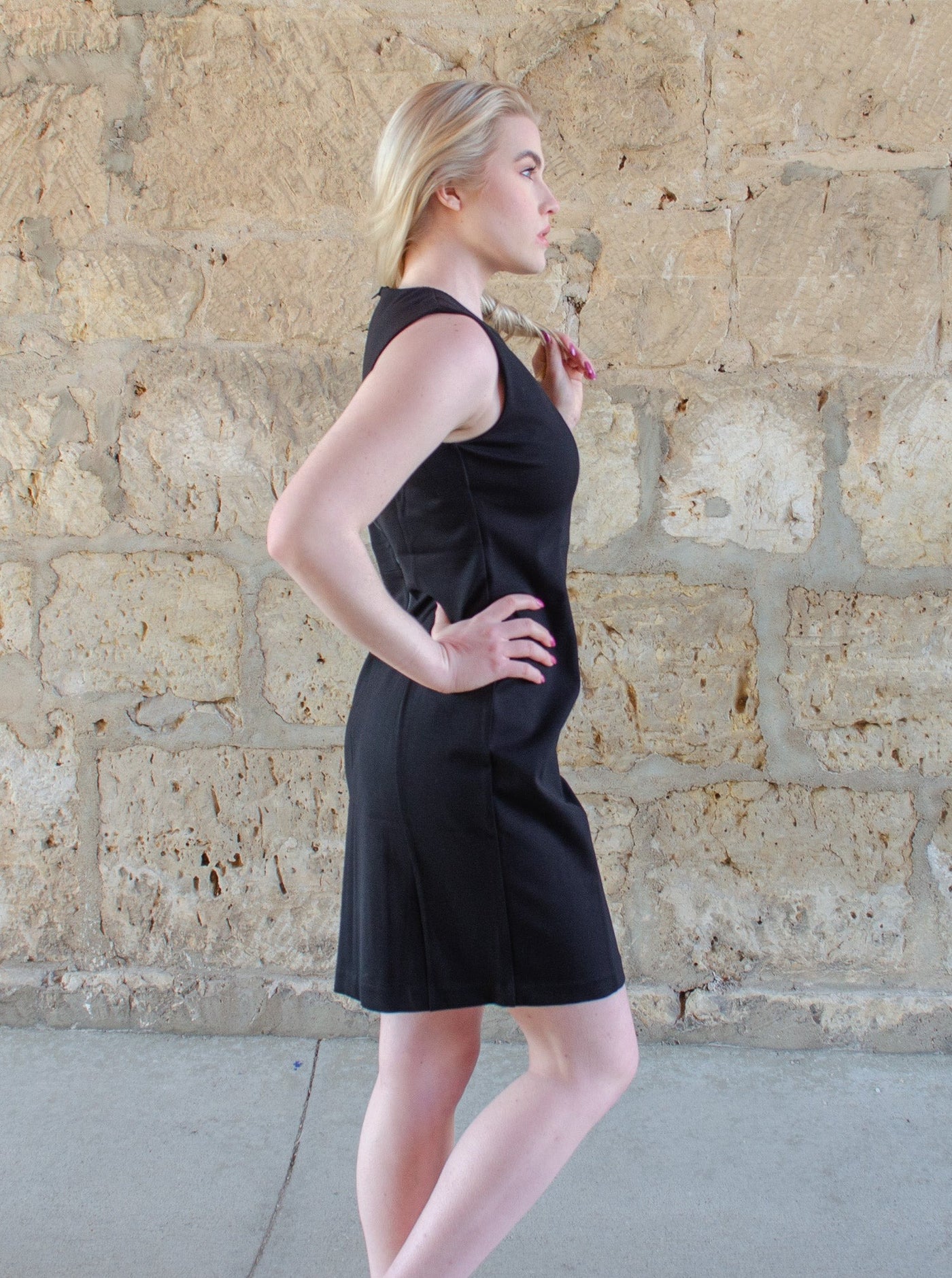 Model is wearing a black professional style midi dress. 