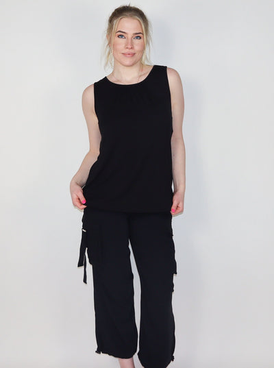 Model is wearing a black tank top with 2" inch straps. Tank is paired with black cargo pants.
