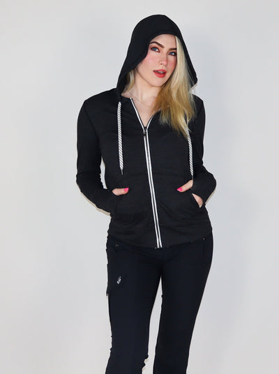Model is wearing a deep charcoal colored fitted zip up with white trimming and white drawstrings.