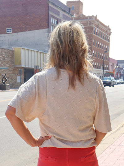 Textured beige colored flowy t-shirt worn with coral pull on pants.