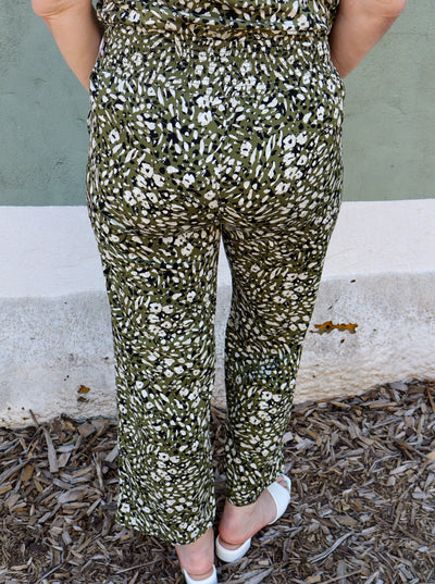 Model is wearing a green white and black cheetah print pull on pant paired with a matching cami.