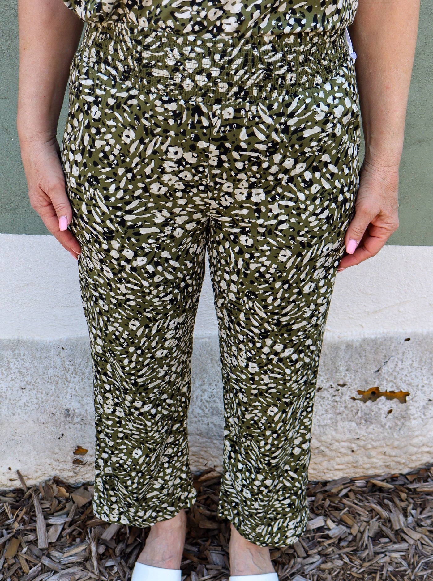Model is wearing a green white and black cheetah print pull on pant paired with a matching cami.