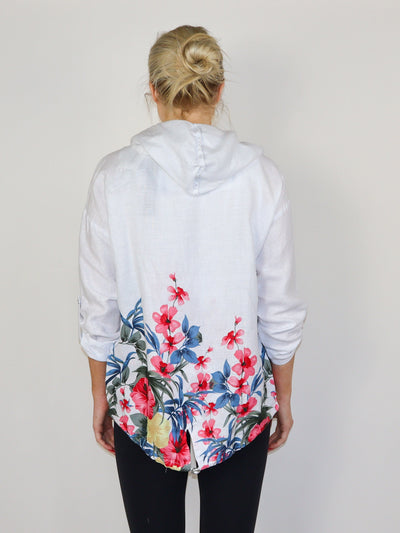 Model is wearing a white and floral printed hooded linen cardigan. Paired with a matching tank top and black pants.