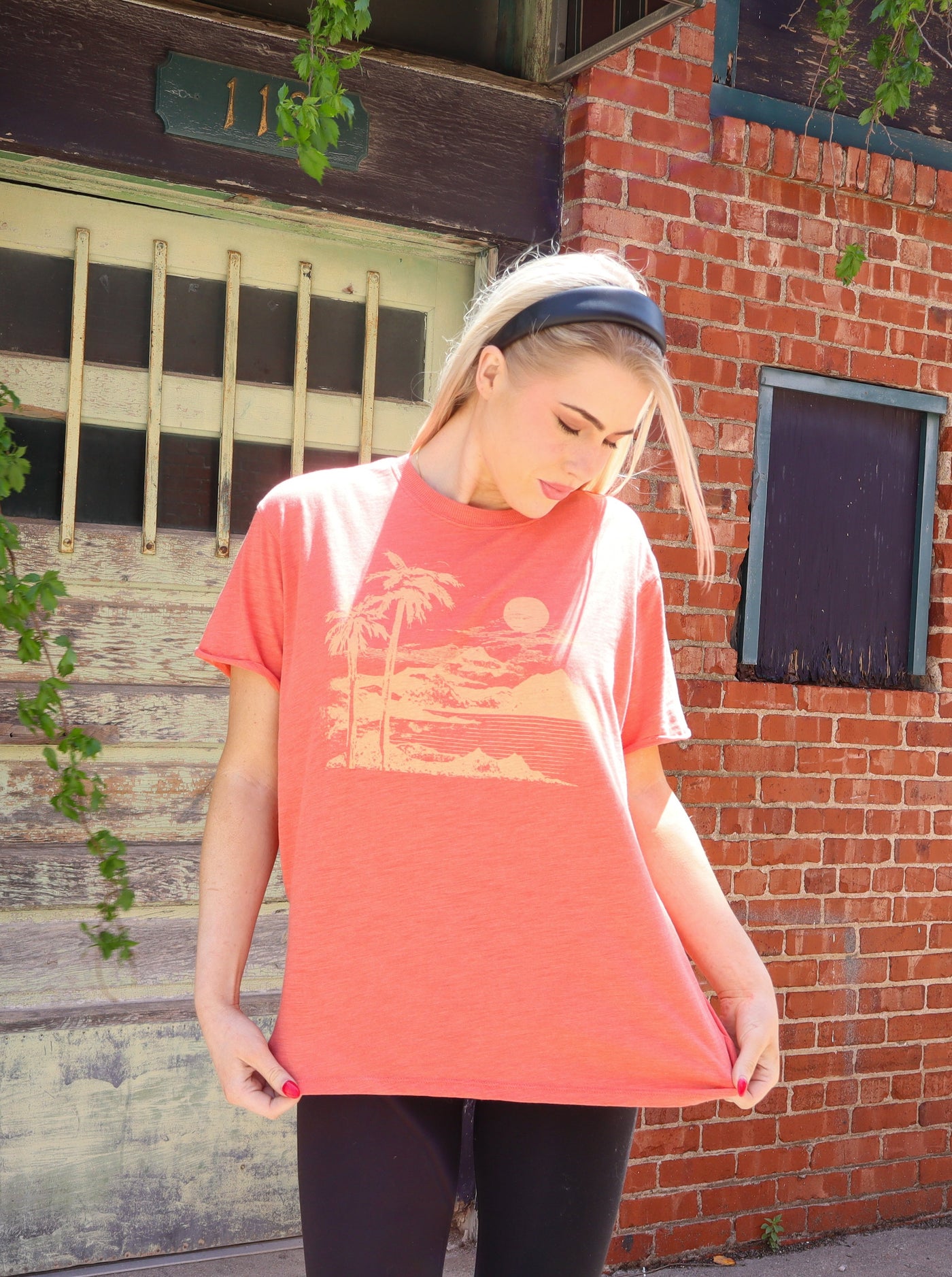 Burnt orange colored over sized tee with a beach graphic print. Worn with leggings.