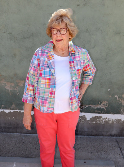 Model is wearing a multi color plaid patch work button up collared long jacket.