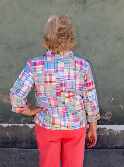 Model is wearing a multi color plaid patch work button up collared long jacket.