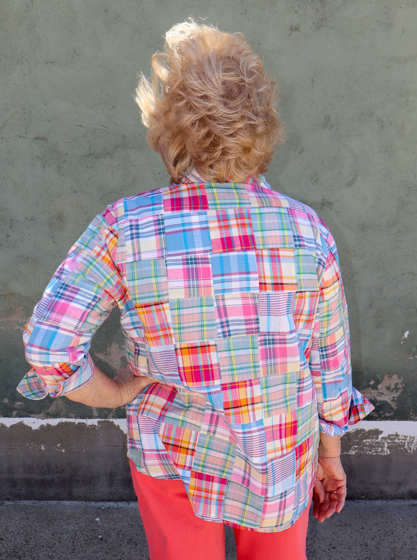 Model is wearing a multi color plaid patch work button up collared long sleeve top.