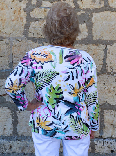 Model is wearing a multi colored tropical printed v-neck tunic top.