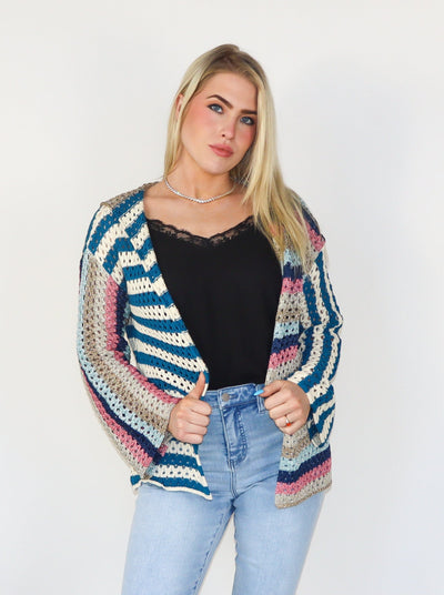 Multi colored hooded crochet cardigan. Worn with a black tank top and blue jeans.