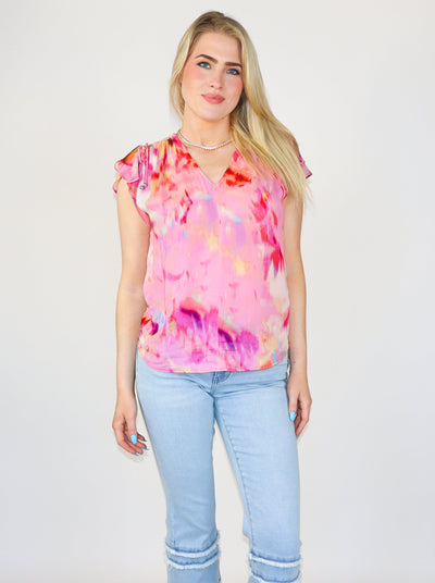 Model is wearing a sheer fuchsia water color blouse: V-neck; Shirred detailing; Drawstring arm trims; Petal sleeves; Rounded hem