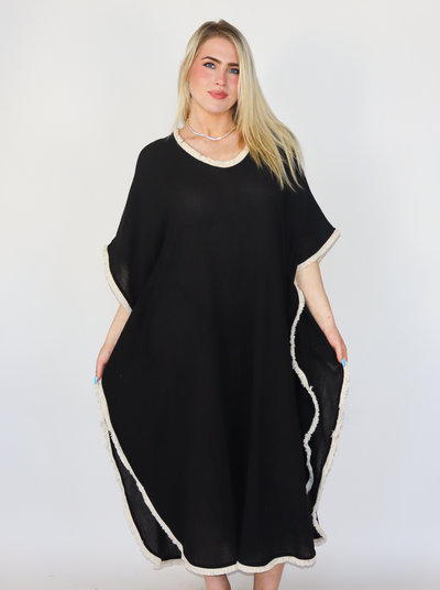 Model is wearing a frayed hemming black one size fits all kaftan. 