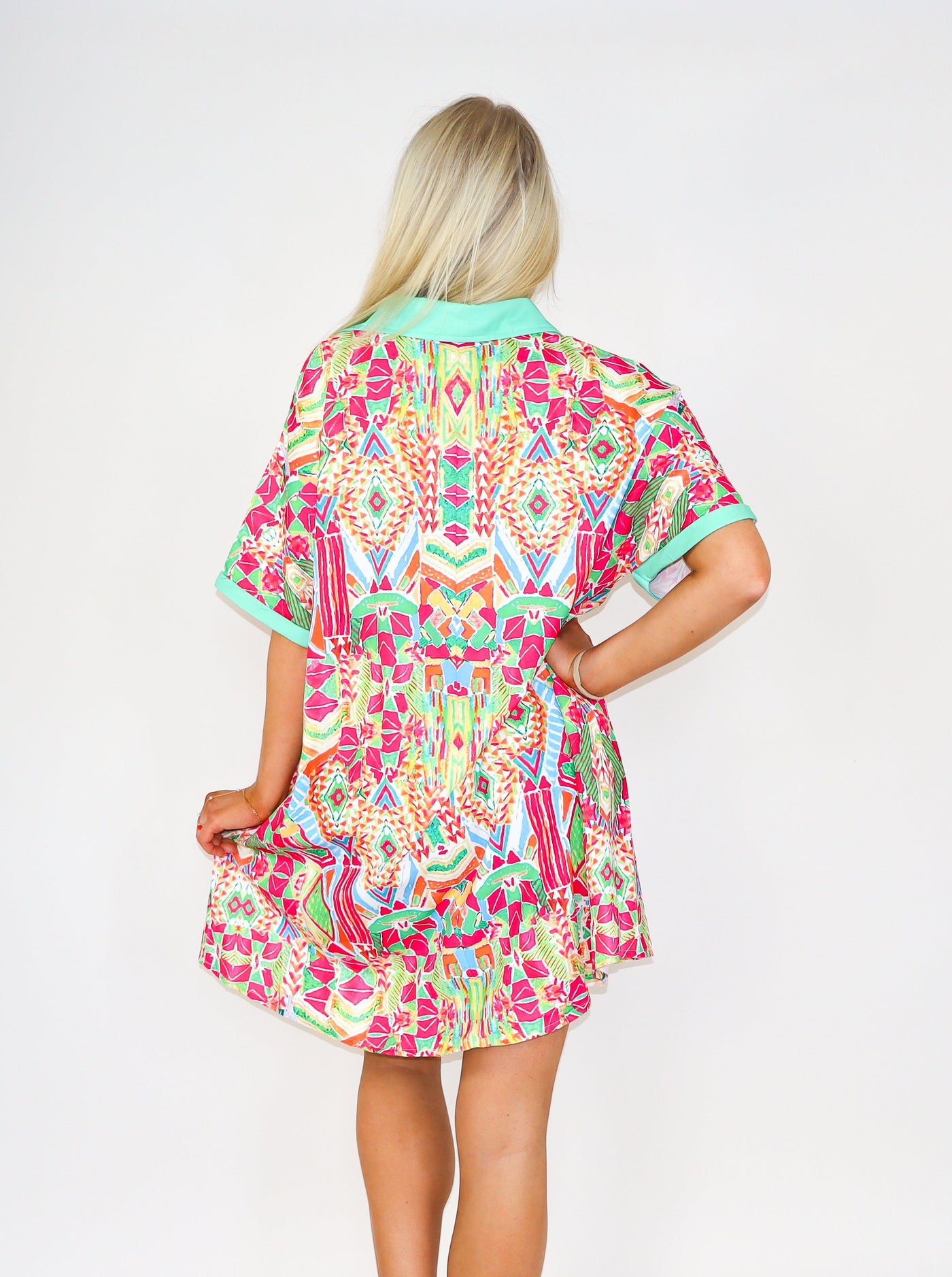  Model is wearing a button up geometric printed multi colored button up t-shirt dress.