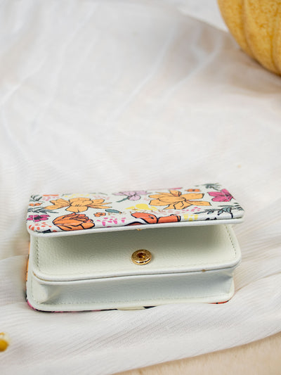 A white card and cash holder with a yellow, pink, teal, yellow, and purple flower design on it. The wallet folds and has a gold snap and 3 pockets inside. 