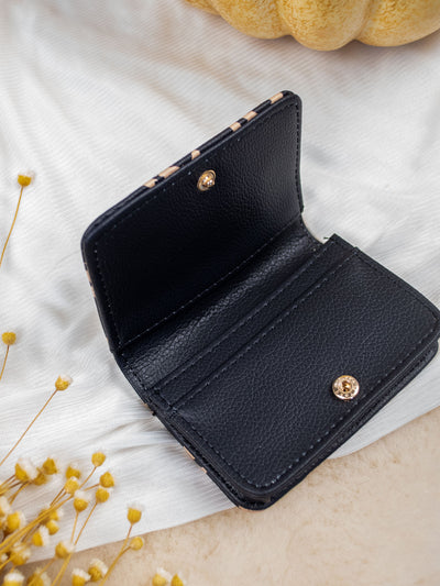 A white card and cash holder with a brown and black leopard print. The wallet folds and has a gold snap and 3 pockets inside. 