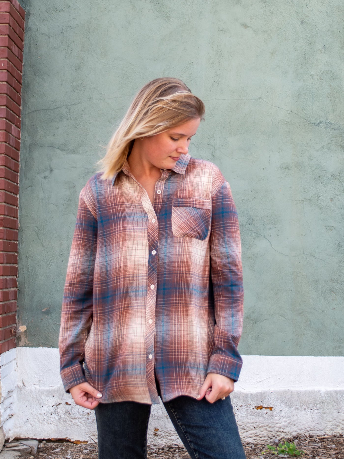 A model wearing a brown and blue button down flannel. The model has it paired with gray jeans.