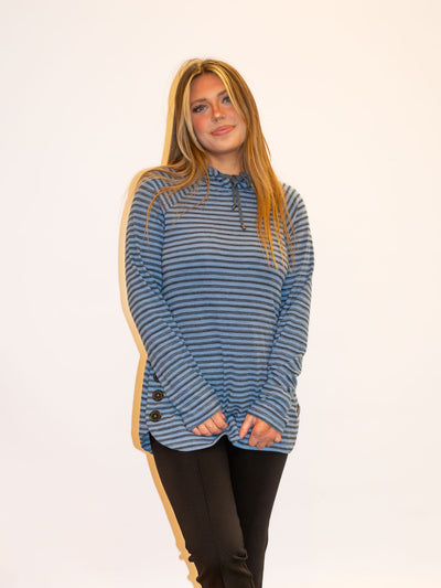 A model wearing a blue and gray striped top with button details on the side. The model has it paired with black leggings.