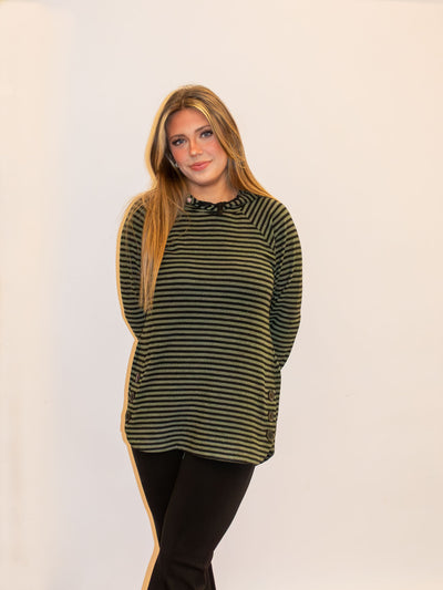 A model wearing an olive and black striped top with button details on the side. The model has it paired with black leggings.