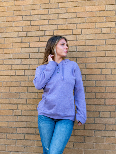 A model wearing a light purple fleece hoodie. The model has it paired with a pair of medium wash jeans.