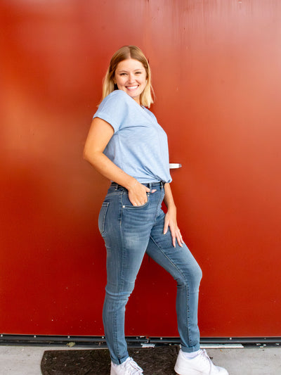 A model wearing a pair of light wash skinny jeans. She has it paired with a light blue t-shirt and white sneakers. 