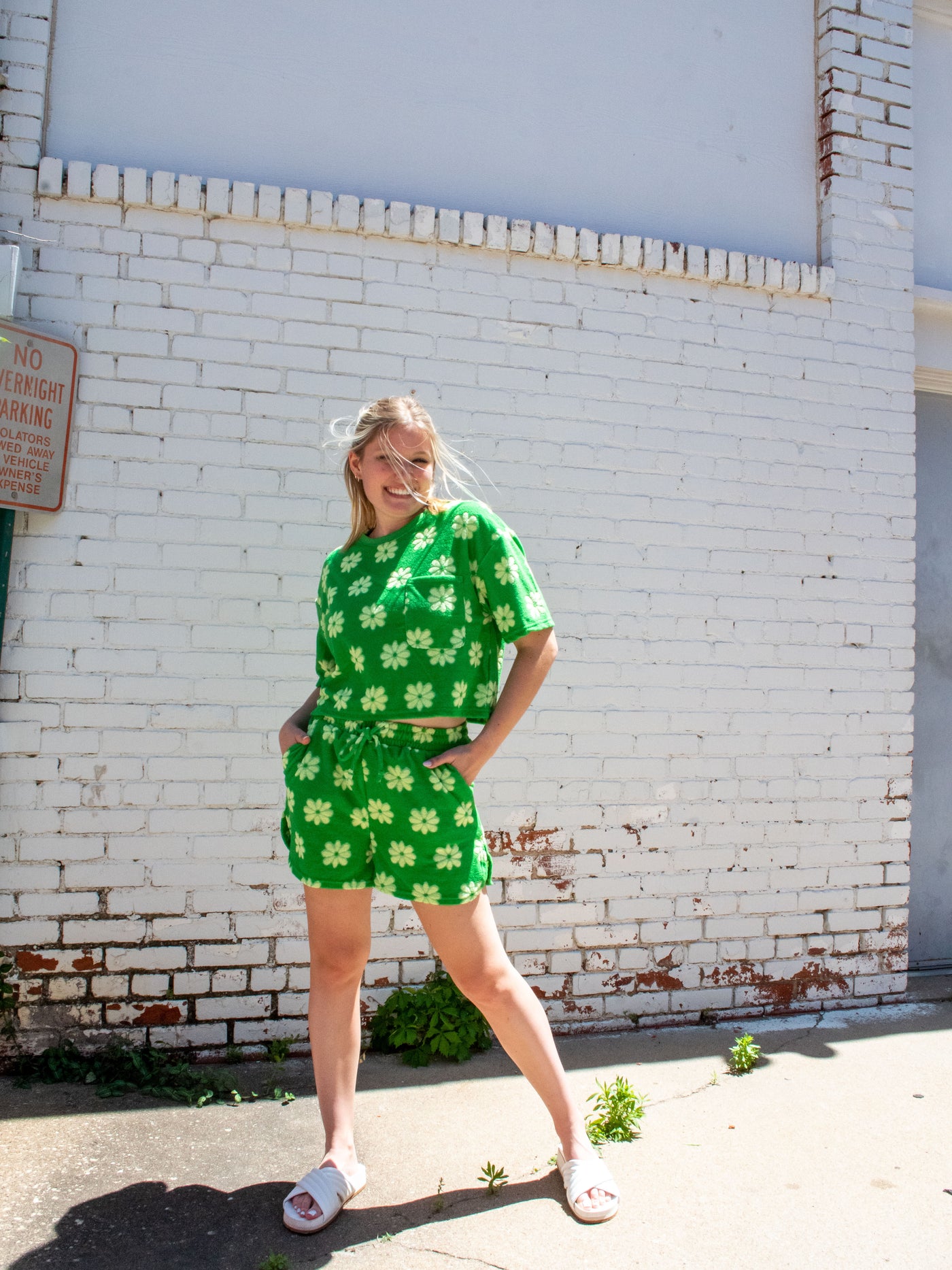 A model wearing a green floral jacquard French Terry set. She has mini shorts and matching shirt in it on.