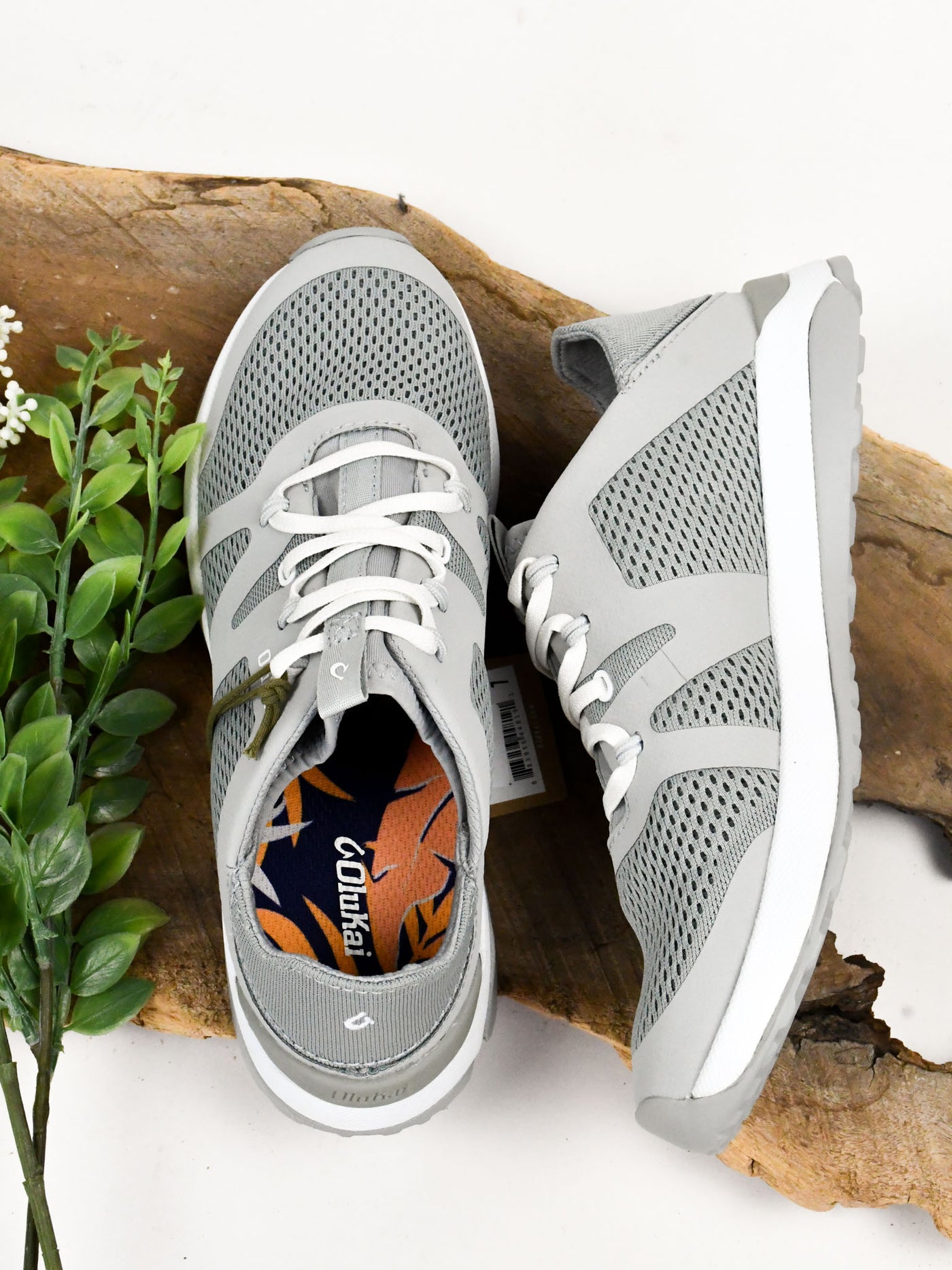 A gray women's athleisure sneaker with white laces.