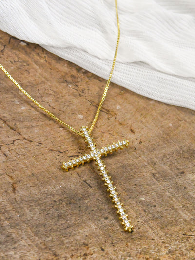 A gold cross necklace with CZ stone details.