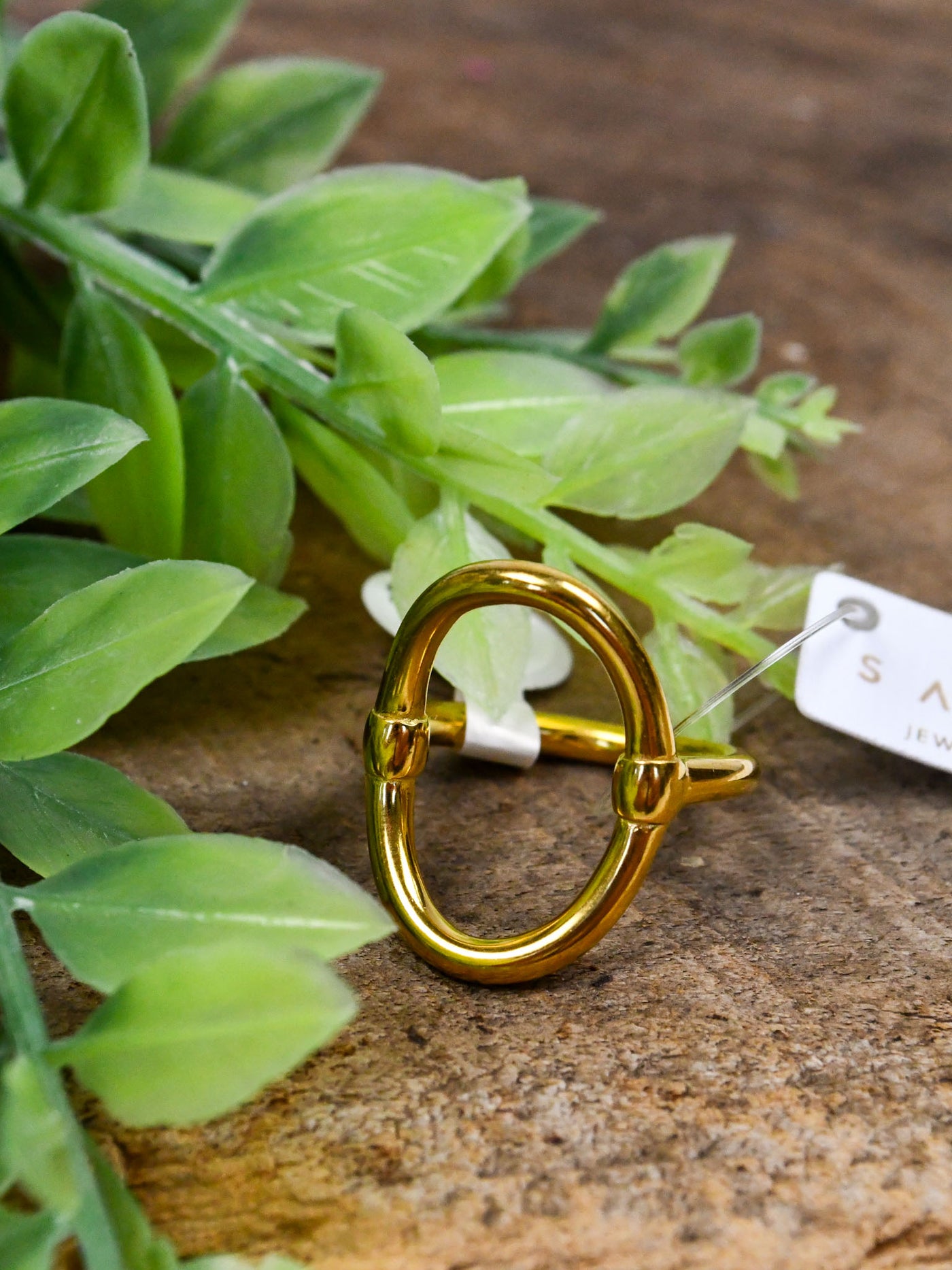 A gold ring featuring a statement oval piece in the center.