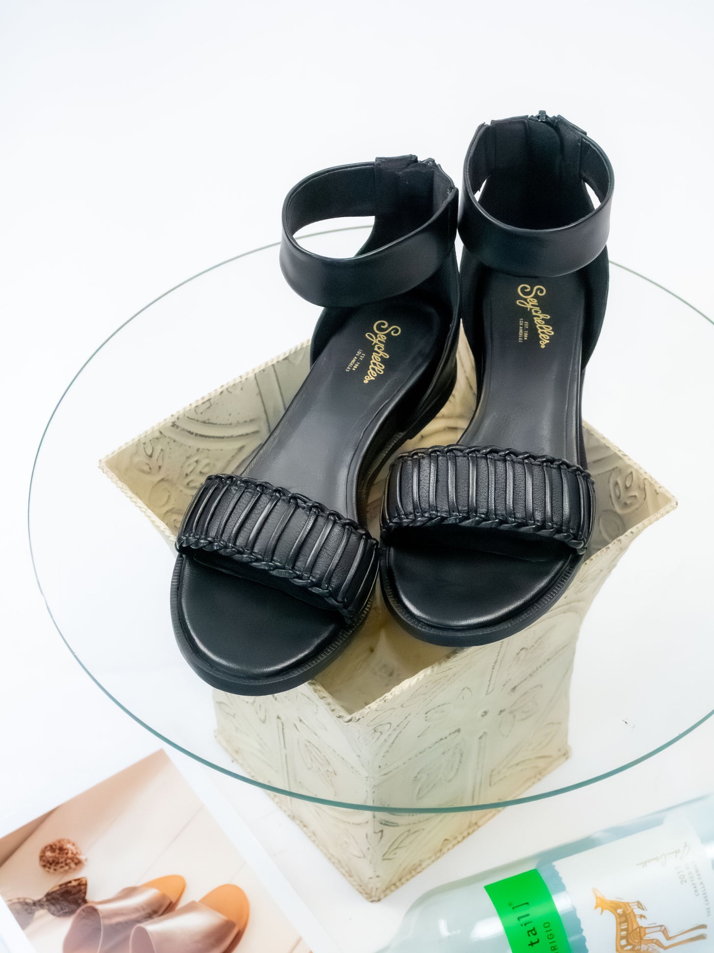 A pair of black leather wedge sandals.