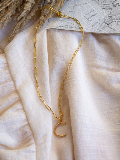 A square link/ paperclip style chain necklace with a twisted capital C attached to it.