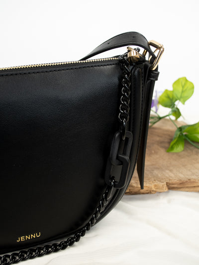 A black vegan leather shoulder bag with a chain strap and two compartments.