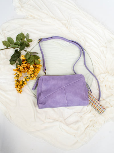 A purple antiqued vegan leather crossbody, clutch, or wristlet style purse.