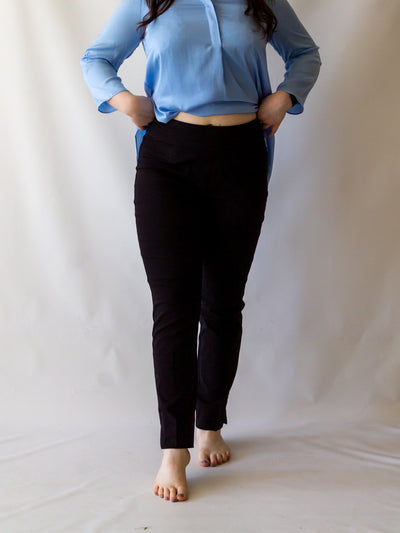 A model wearing a pair of black colored cigarette pants and a light blue blouse.