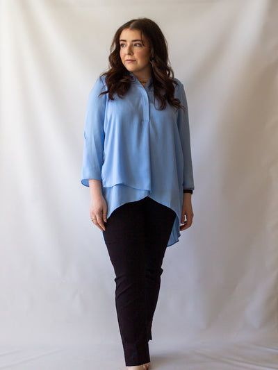 A model wearing a pair of black colored cigarette pants and a light blue blouse.