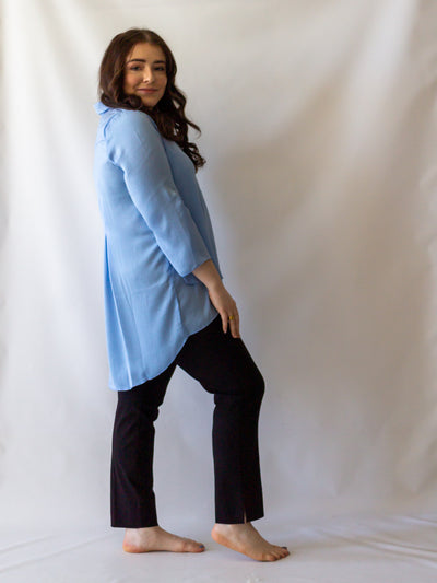 A model wearing a light blue, long flowy pants with black colored cigarette style pants.