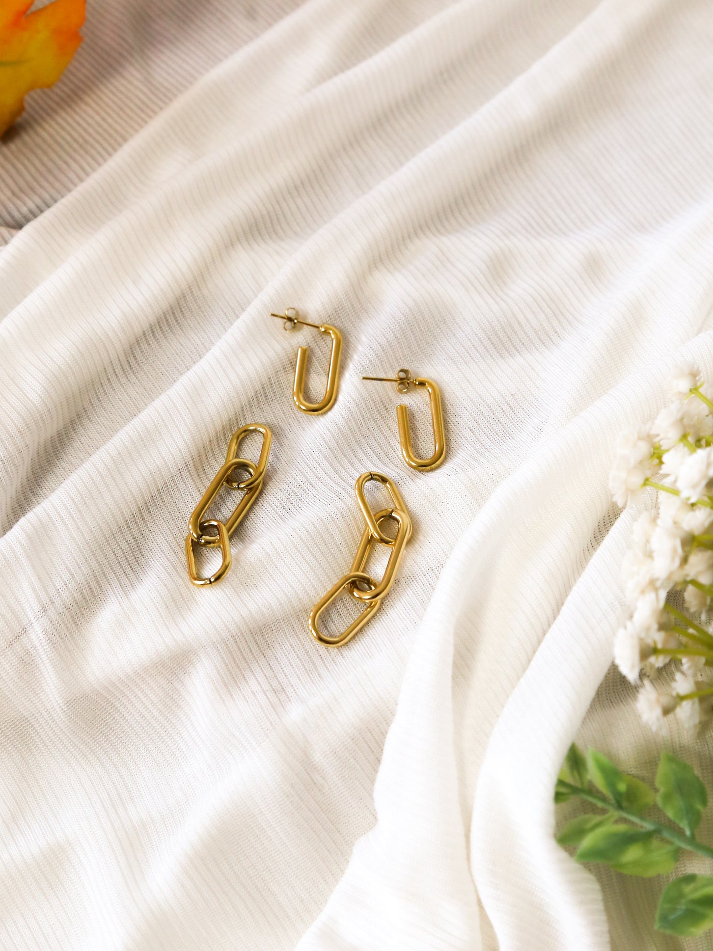 A pair of gold paperclip link earrings.