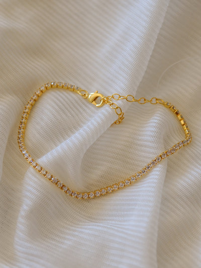 A gold chain tennis bracelet inlaid with cubic zirconia crystals.