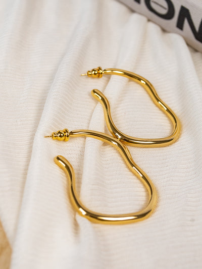 A pair of wavy gold hoop earrings.