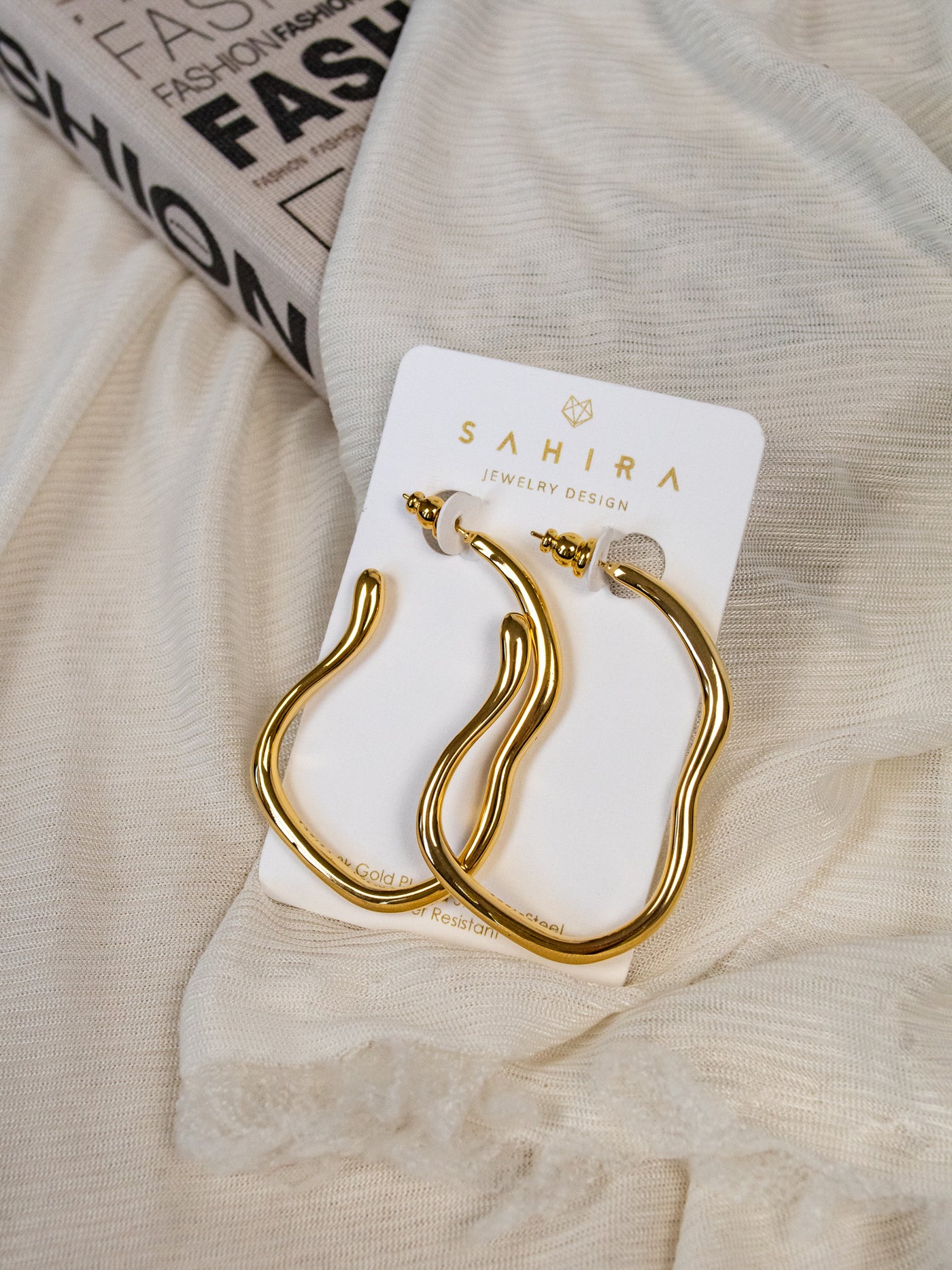A pair of wavy gold hoop earrings.