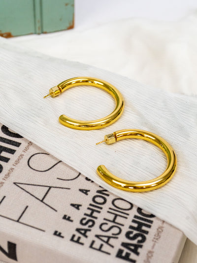 A pair of 2" gold plated hoop earrings.