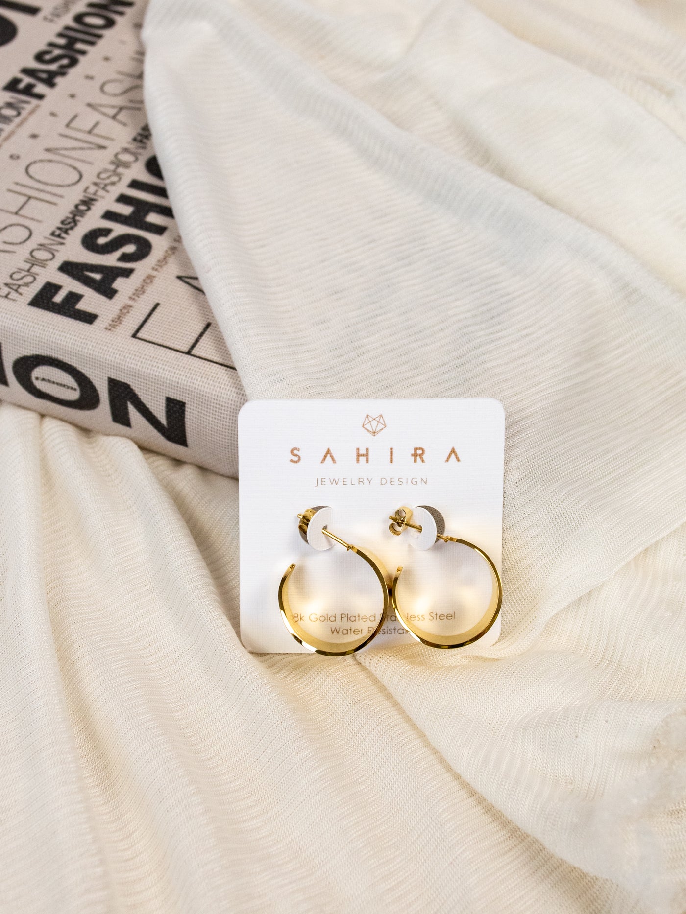 A pair of mini gold tapered hoop earrings.